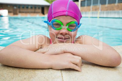 Portrait of young girl wearing swimming goggles in pool