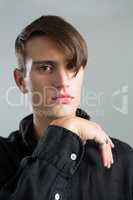 Androgynous man posing with hand on chin