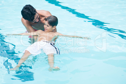 Father and son playing in pool