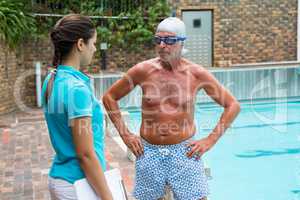 Swim coach interacting with senior man