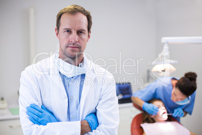 Dentist standing with arms crossed in clinic