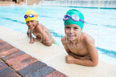 Two kids smiling in the pool