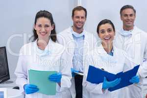 Smiling dentists standing in dental clinic