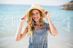 Smiling young woman standing against sea