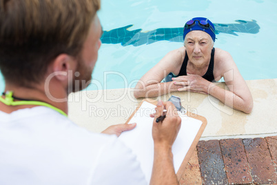 Swim coach interacting with senior woman