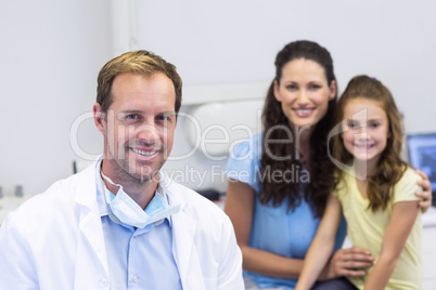Portrait of dentist with young patient and her mother