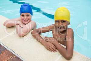 Two smiling kids standing in swimming pool