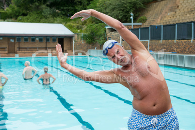 Smiling senior man excerising at poolside