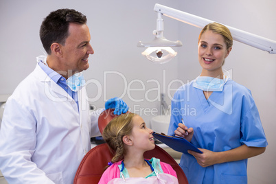 Dentist and young patient looking at nurse