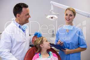 Dentist and young patient looking at nurse