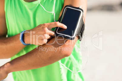 Man using phone while listening to music at beach