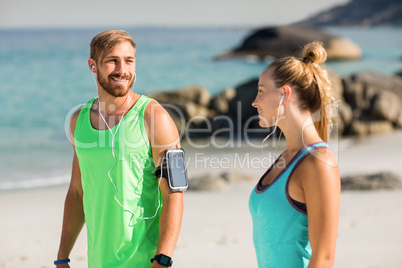 Couple listening music while standing at beach