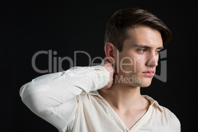 Androgynous man posing with hand on his neck