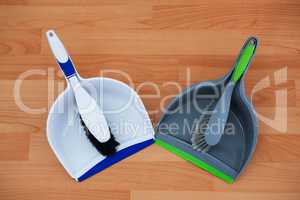 Overhead view of brushs with dustpans on hardwood floor