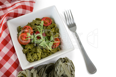 Close up of pasta in bowl by napkin