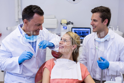 Dentists interacting with female patient