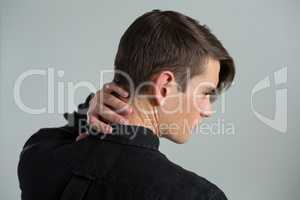 Androgynous man touching his neck