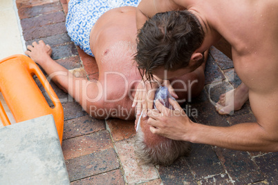 Lifeguard helping unconscious senior man