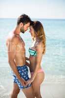 Couple standing face to face on shore at beach