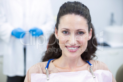 Smiling female patient sitting on dentist chair