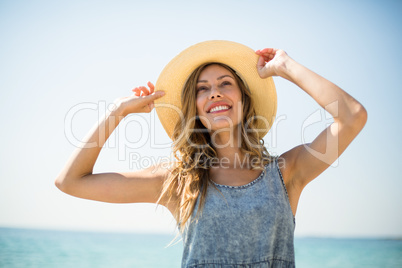 Smiling young woman standing against sky