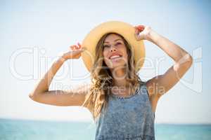 Smiling young woman standing against sky