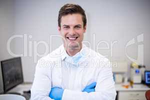 Portrait of happy dentist standing with arms crossed