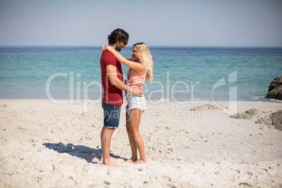 Young couple standing face to face at beach