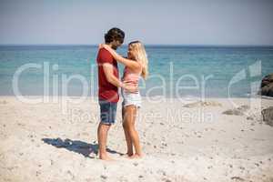 Young couple standing face to face at beach