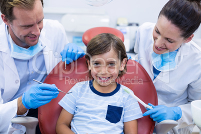 Smiling dentists examining young patient