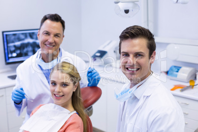 Portrait of smiling dentists and female patient