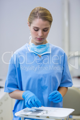 Female nurse picking up dental tools