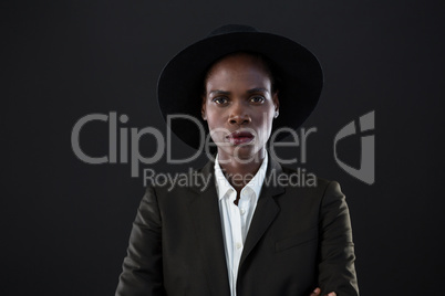 Androgynous man in suit posing against grey background