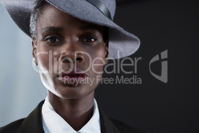 Androgynous man in hat against grey background