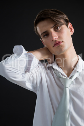 Androgynous man posing with hands on his head