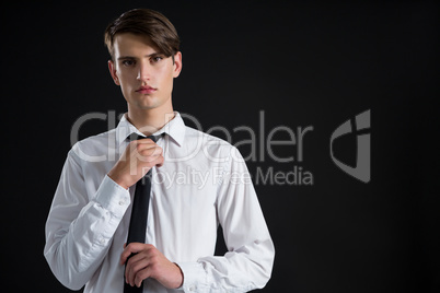 Androgynous man adjusting his tie