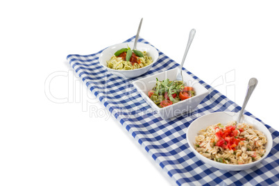 High angle view of pasta served in bowls on napkin