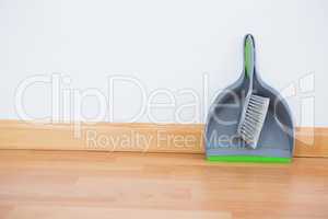 Close up of brush and dustpan against wall