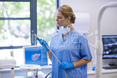 Female nurse holding dental tool