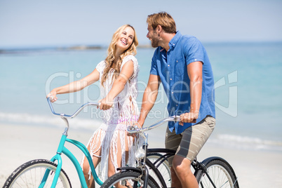 Couple riding bicycles at beach