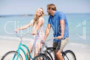 Couple riding bicycles at beach