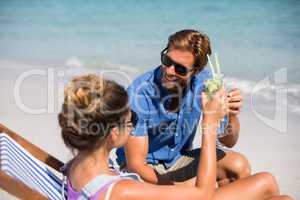 Couple having drinks on shore at beach