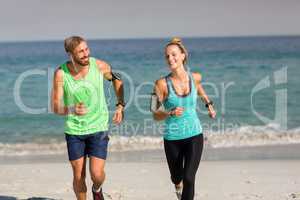 Young couple smiling while jogging