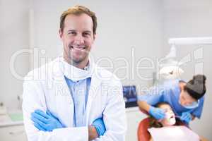 Dentist standing with arms crossed in clinic