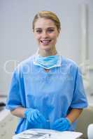 Portrait of happy female nurse holding dental tool