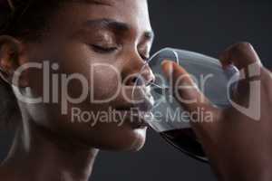 Androgynous man drinking wine from glass