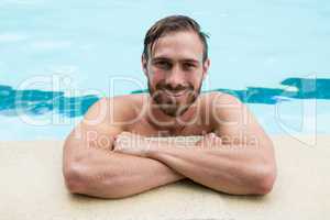 Smiling lifeguard leaning on poolside