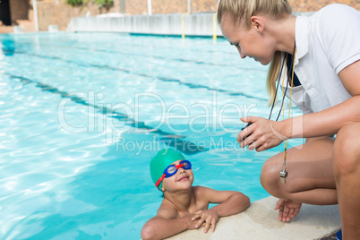 Female trainer showing stopwatch to boy