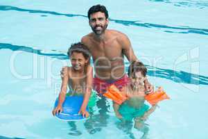 Father and kids smiling in the pool