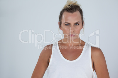 Beautiful transgender woman standing over gray background